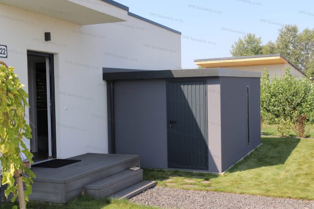 Moderný záhradný domček v tmavosivej farbe pri rodinnom dome