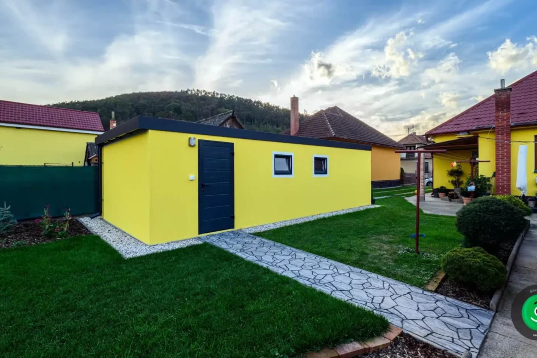 Trávnik v okolí montovanej garáže.