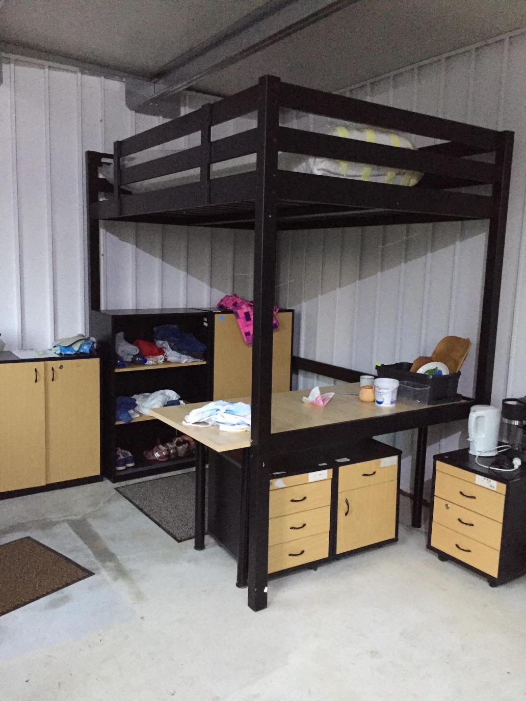 Útulný priestor so skrinkou na oblečenie a vysokou postelou