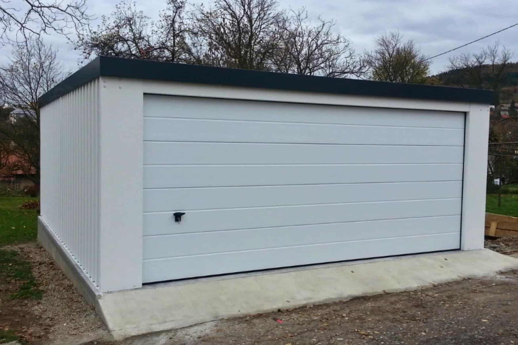Prefabrikovaná betónová garáž s bielou bránou.