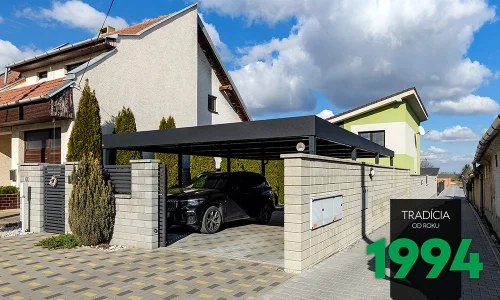 Auto pod prístreškom za murovaným plotom