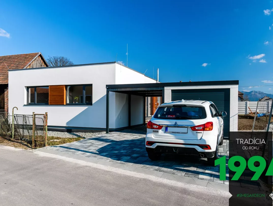 Biele auto pred garážou s prístreškom pri dome