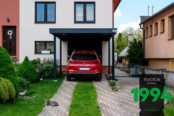 Červené auto pod prístreškom pre jedno auto