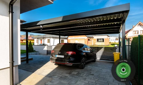 Auto pod prístreškom za samonosnou bránou