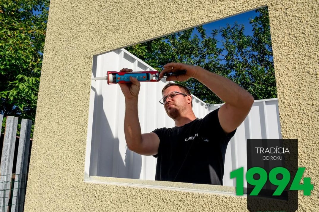 Montážnik Gardeonu nanáša tesniaci tmel do otvoru pre okno.