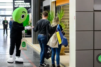 Maskot rozdáva maličkosti zákazníkom