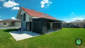 Pergola GARDEON v z&aacute;hrade hneď vedľa bieleho domu.