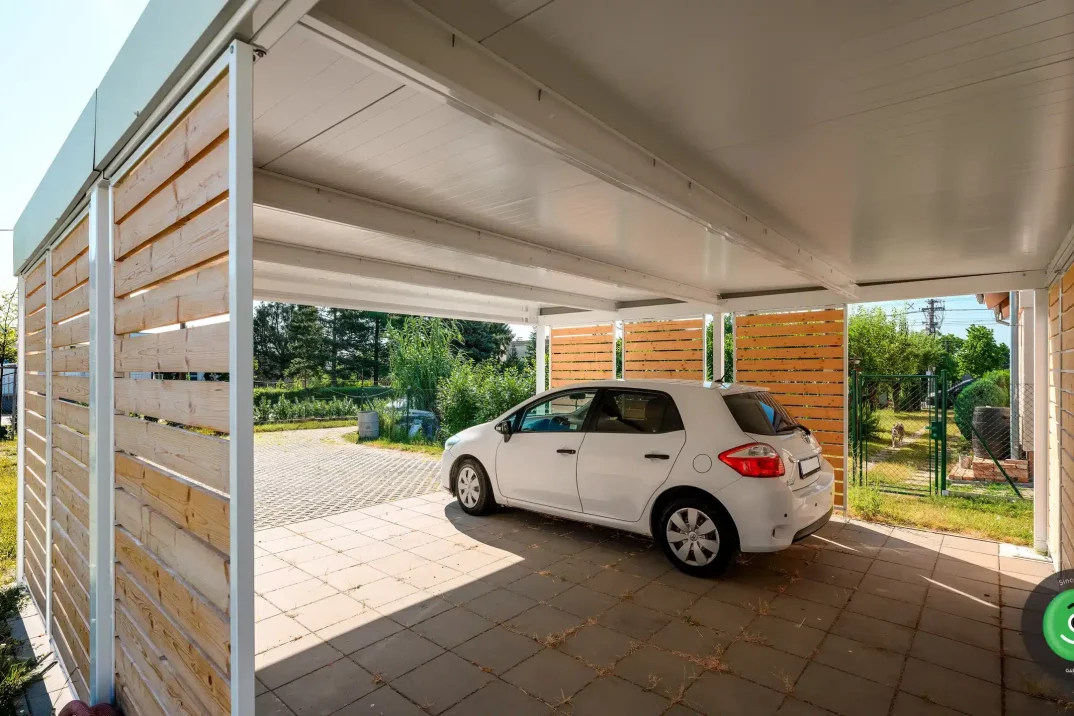 GARDEON prístrešok s bielou strechou a hnedou drevenou výplňou.