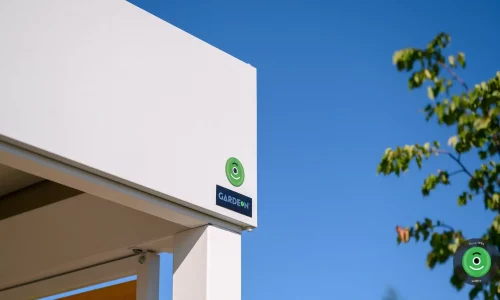 Detail na logo firmy GARDEON umiestnený na bielej atike prístrešku.