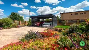 Pr&iacute;stre&scaron;ok pre aut&aacute; na z&aacute;mkovej dlažbe obklopen&yacute; kvetinovou z&aacute;hradou.