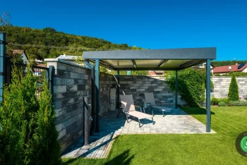 Gardeon pergola na zelenej záhrade pri plote.