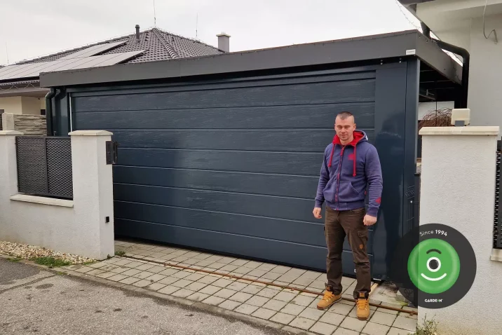 Spokojný zákazník pred prístreškom s garážovou bránou