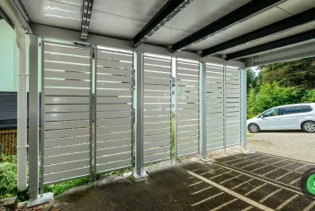 Detail na bielu kovovú výplň v prístrešku pre dve autá.