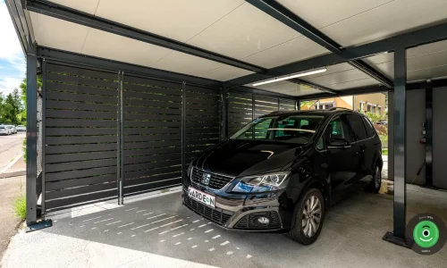 Čierne auto v prístrešku s čiernou kovovou výplňou