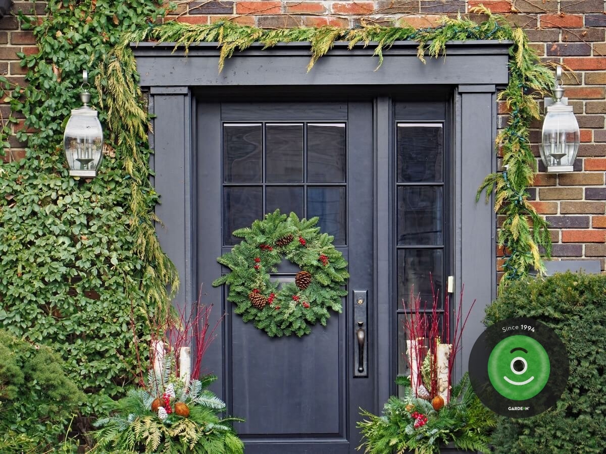 Vianočne ozdobené dvere vencom a dekoráciami.
