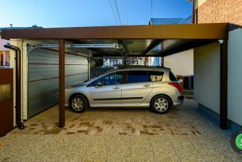 Strieborné auto pod prístreškom GARDEON s garážovou bránou