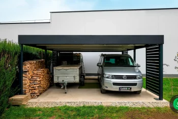 Auto zaparkované pod prístreškom, ktorý slúži aj na odkladanie dreva.