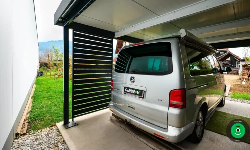 auto pod prístreškom s čiernou kovovou výplňou
