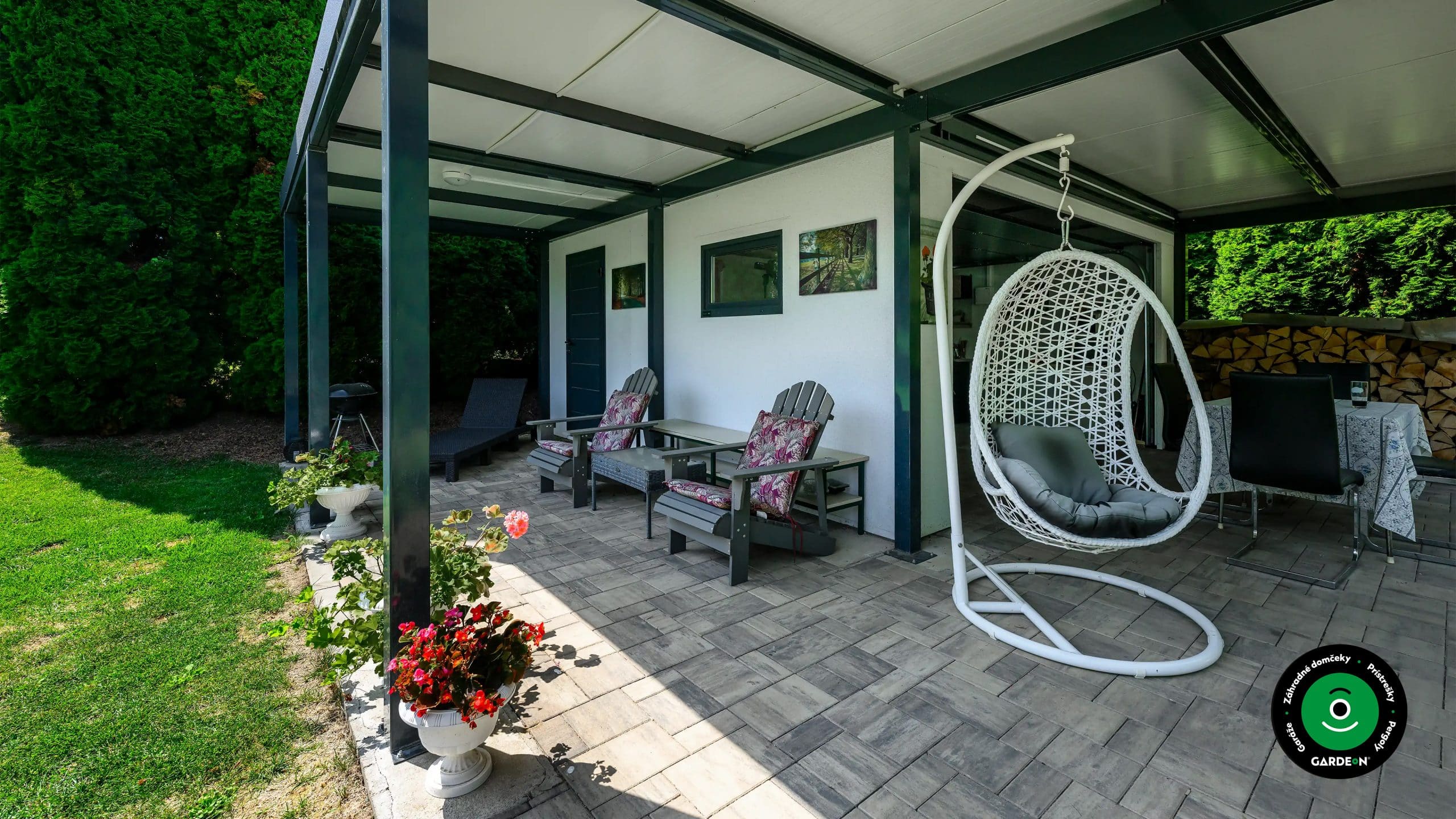 Záhradný domček s prístreškom poskytujúcim tieň pre letné posedenie.