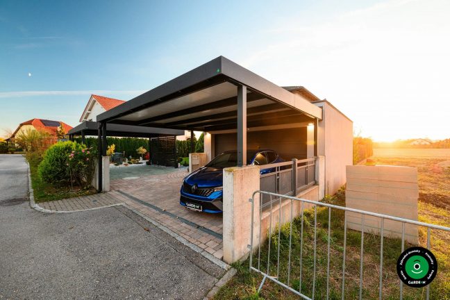 Priestranná garáž prístrešokom, dlažbou a výhľadom na upravenú záhradu