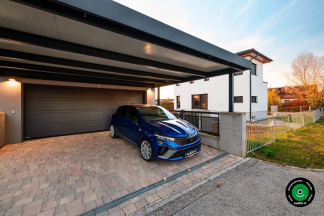 Gatáž s prístreškom pri dome s modrým autom zaparkovaným