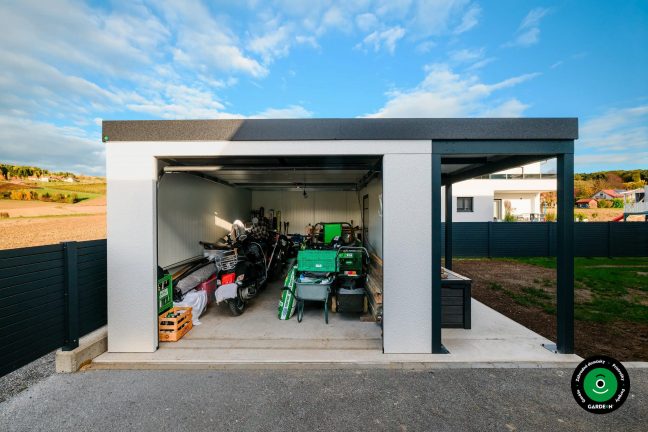 Otvorená garáž plná náradia a uložených motoriek