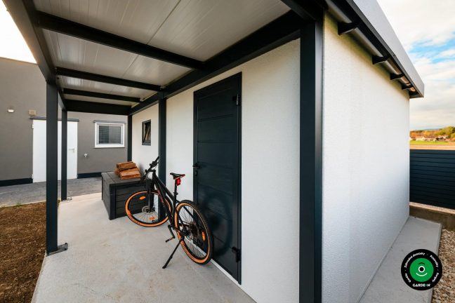 Prístrešok pri garáži s bicyklom opretým o stenu