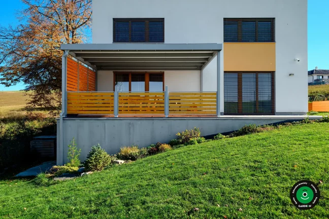 Pergola poskytujúca tieň nad posedením na domovej terase