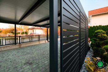 Detail bočnej výplne prístrešku s výhľadom do záhrady.