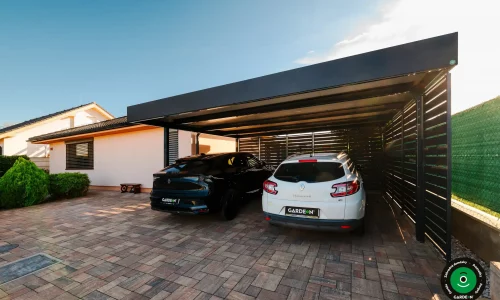 Prístrešok s čiernym a bielym autom chránenými pod pevnou strechou