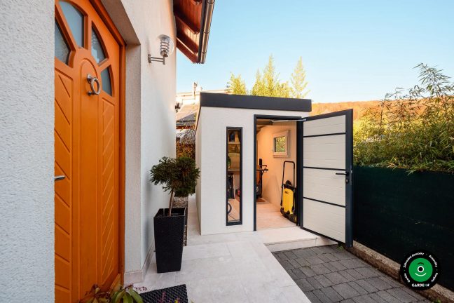 Záhradný domček pri dome s otvorenými dverami a vybavením