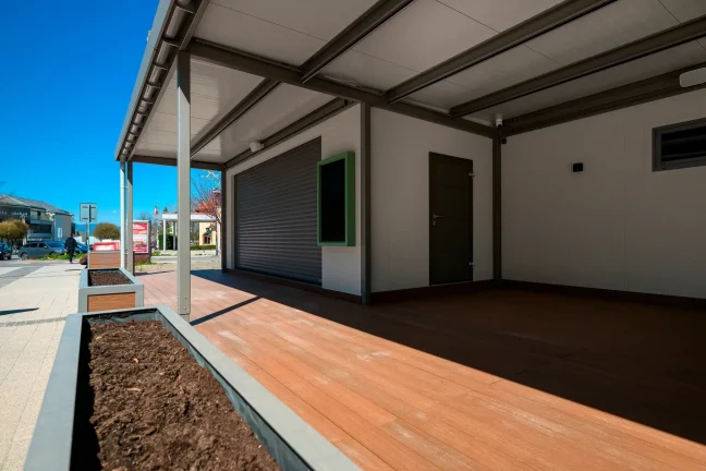 Moderný zmrzlinový kiosk s prestrešenou oddychovou zónou pre návštevníkov