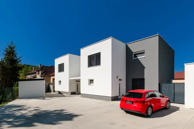 Moderný záhradný domček s prístreškom pri minimalistickom rodinnom dome