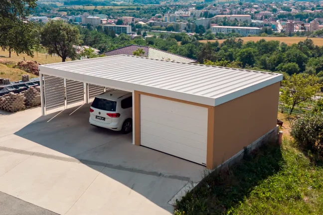 Tehlová omietka KABE na garáži s prístreškom s bielou strechou.