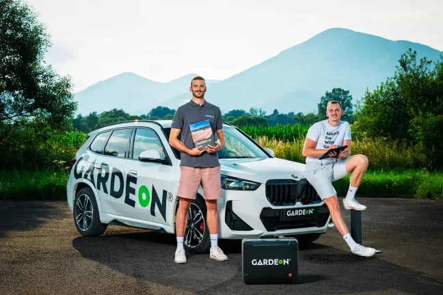 Dvaja zamestnanci GARDEON s vzorkovníkom a tabletom pred firemným BMW.