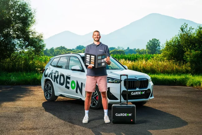 Vzorkovník farieb drží obchodný agent GARDEON pred firemným BMW.