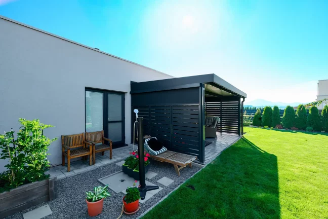 Antracitová pergola s kovovou výplňou v záhrade rodinného domu.