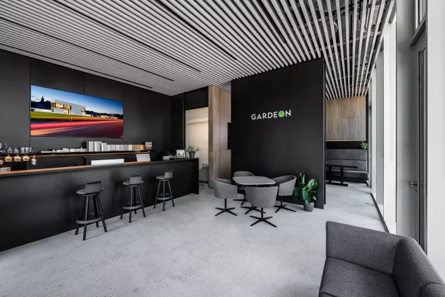 Moderný showroom GARDEON s čiernou stenou, barovým pultom a lamelovým stropom