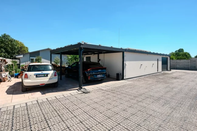 Predný pohľad na dom s dvoma autami pod prístreškom