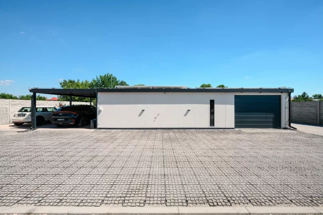 Predný pohľad na dom so zeleným autom Gardeon a solárnou stenou