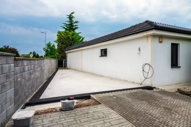 Pripravená betónová plocha pri dome pred montážou garáže