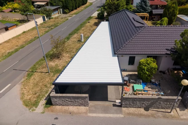 Letecký pohľad na dlhú bielu strechu garáže popri ceste.