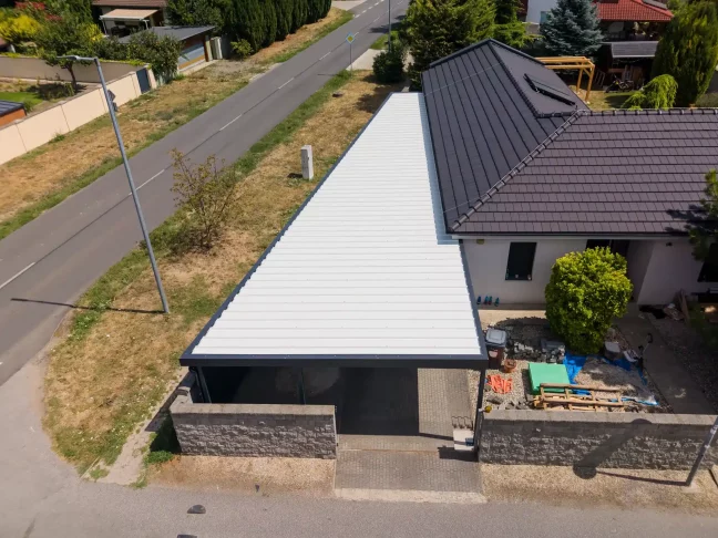 Letecký pohľad na dlhú bielu strechu garáže popri ceste.