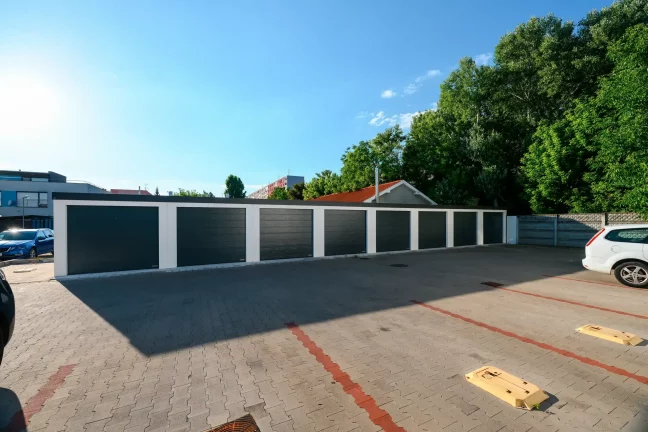 Celkový pohľad na rad garáží s dvoma parkujúcimi autami