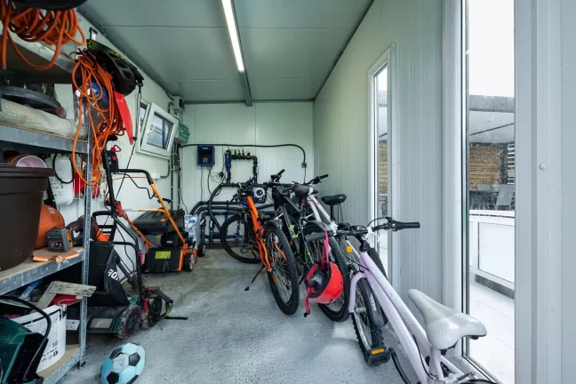Sklad s bicyklami kosačkou a záhradným náradím na regáli