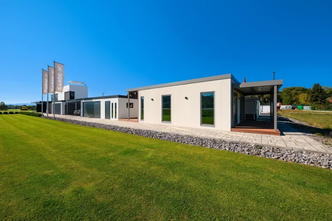 Tiny house v showroome Gardeon z diaľky, bočná stena s oknami pri trávniku