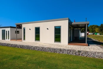 Bočný pohľad na tiny house s krytou terasou a štrkovým lemom
