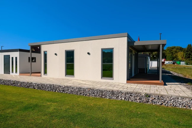 Bočný pohľad na tiny house s krytou terasou a štrkovým lemom