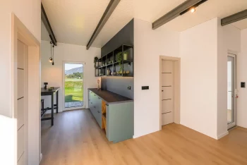 Chodba tiny housu s kuchynskou linkou a dverami do ďalších miestností