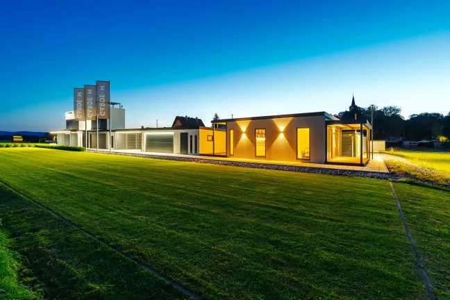 Večerný pohľad na osvetlený showroom Gardeon s tiny housom